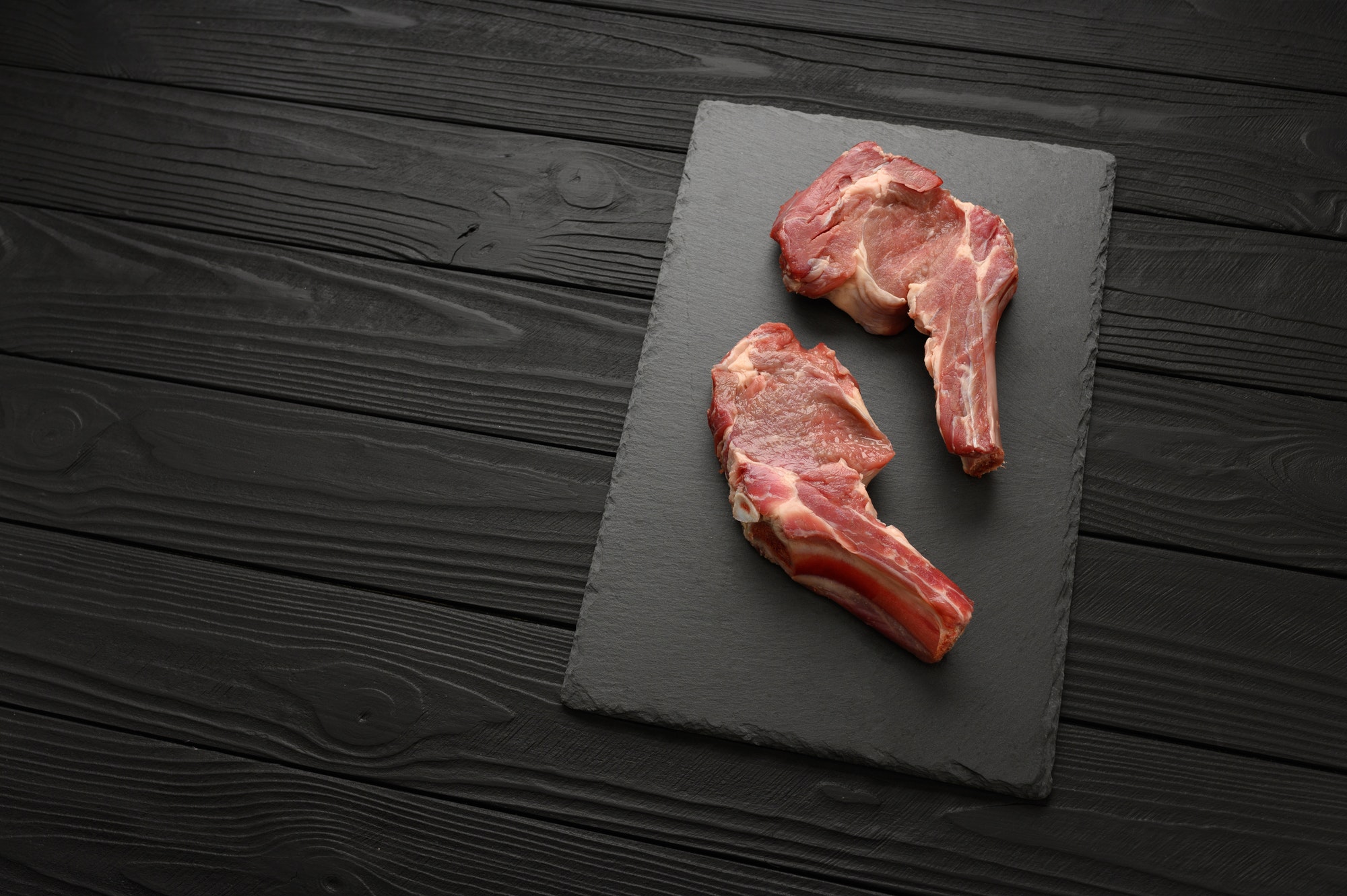 Raw fresh meat bison on black wooden background